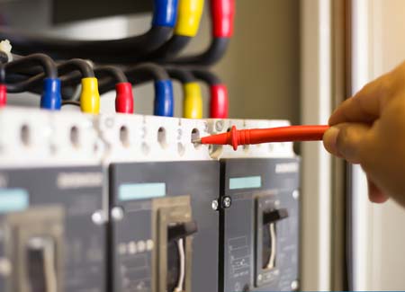 Professional maintenance technician testing controllers of mosquito misting system to ensure operation at optimum efficiency    